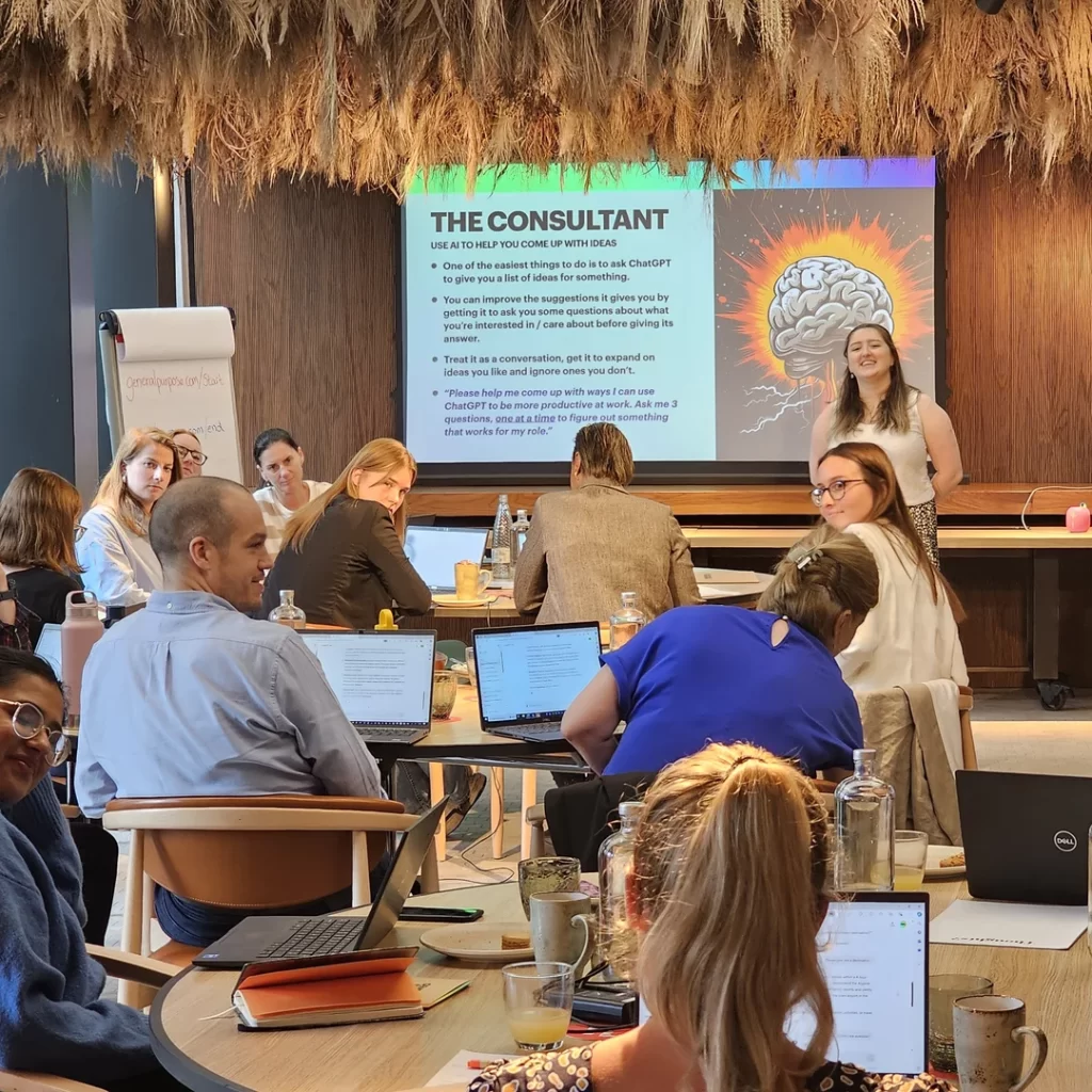 Kirstie Kavanagh presenting an AI Essentials workshop to a group of professionals working on laptops at General Purpose Training, with a slide titled “The Consultant” displayed behind her.