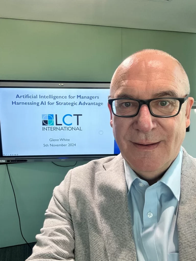 Glenn White from City Folk Digital presenting an AI training session for managers titled "Harnessing AI for Strategic Advantage" in front of a presentation screen.